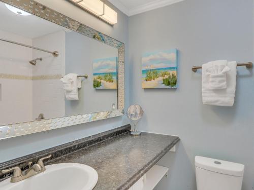 ein Badezimmer mit Waschbecken, Spiegel und Toilette in der Unterkunft Sea Stallion in Tybee Island