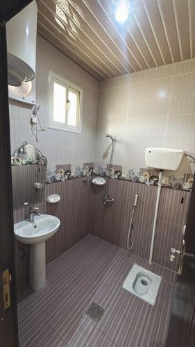 a bathroom with a sink and a shower and a toilet at شقق ملفا للشقق الفندقية-شقق مخدومة- اقتصادي2 in Nughaylah