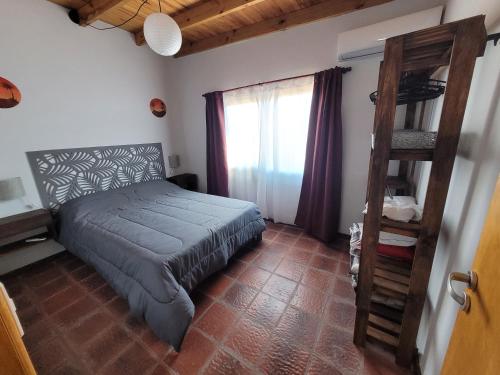 ein Schlafzimmer mit einem Bett mit einer Leiter und einem Fenster in der Unterkunft Casas Sigfrid & Max in Camet Norte