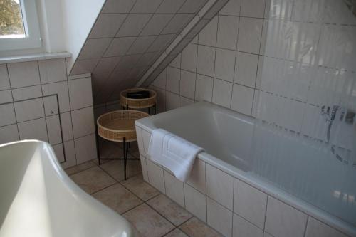 カステラウンにあるAm Apfelbaum, ein Ferienhaus zwischen Rhein und Moselの白いバスルーム(バスタブ、テーブル付)