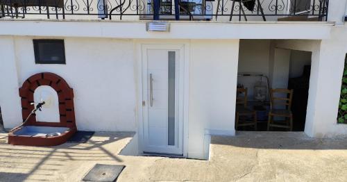 a white building with a door and a balcony at Jennys Vintage Studio - Motorcycle Friendly in Drama