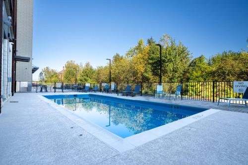 a swimming pool with chairs and a fence at Holiday Inn Express & Suites Murfreesboro West by IHG in Murfreesboro