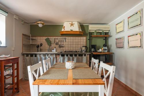 a dining room with a table and a kitchen at Ciauru ri Casa in Mascalucia