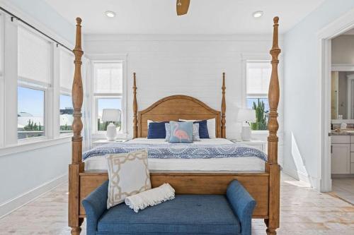 a bedroom with a bed and a chair and windows at Flor Da Li by the Sea in Inlet Beach