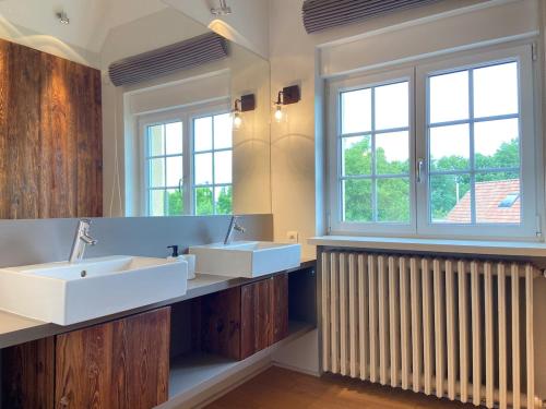 a bathroom with two sinks and two windows at Villa piscine privée 8-10 pers Strasbourg 10 min in Mundolsheim