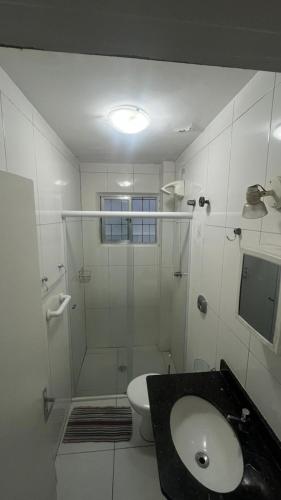 a bathroom with a shower and a toilet and a sink at Apartamento em Pitangueiras in Guarujá