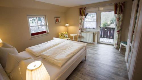 a bedroom with a large white bed in a room at Fewo am Iberg 20, inkl Parkplatz in Willingen