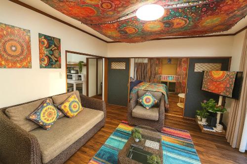 a living room with a couch and a room with a ceiling withpired at Noa ペットOKの一軒家貸切 in Shiraoi