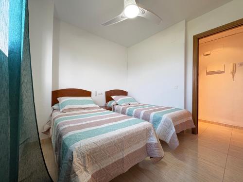 Una cama o camas en una habitación de ACV - Costa Marina II -1ª línea planta 5 sur