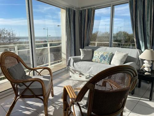 a living room with a couch and chairs at Appartement T2 vue mer les pieds dans l'eau avec parking privé in Saint-Jean-de-Monts