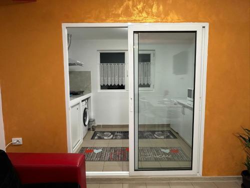 una porta scorrevole in vetro per una cucina con un lavandino di Smart Stay a Craiova