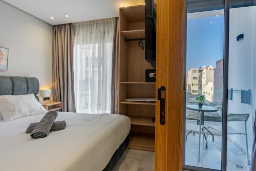 une chambre d'hôtel avec un lit et un balcon dans l'établissement Faya Nova- Appart hotel Central Stay, à Casablanca