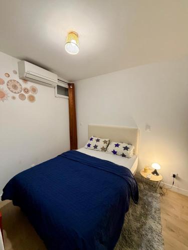 a bedroom with a bed with a blue blanket at Harmony in Limonest