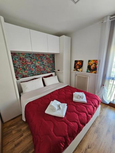 a bedroom with a large red bed with towels on it at Rubin Stay-Karabas Apartments in Vicenza