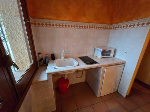a small kitchen with a sink and a microwave at Cortijo de la luna la casita in Taramay