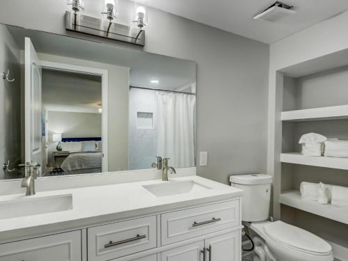 a bathroom with a sink and a toilet and a mirror at Beachside Villa Collection - 6 Bedroom in Tybee Island