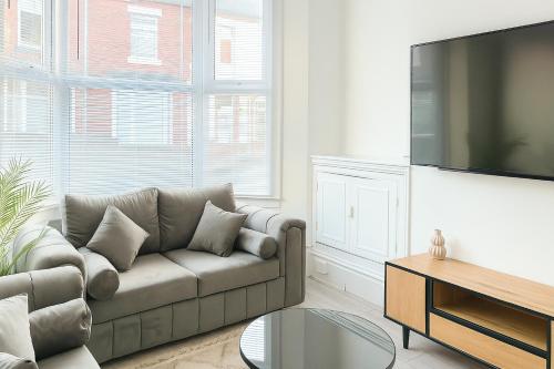 a living room with a couch and a flat screen tv at Quiet & Modern 3-Bed Home Near Beach & Marina in Hartlepool