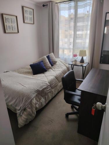 a bedroom with a bed and a desk and a chair at angysol in Antofagasta