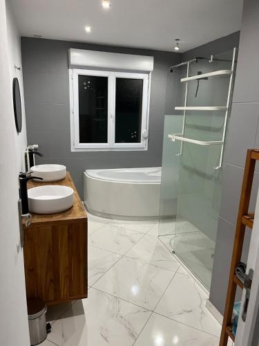 a bathroom with a tub and a sink and a shower at House with Outdoor Jacuzzi in Rocroi