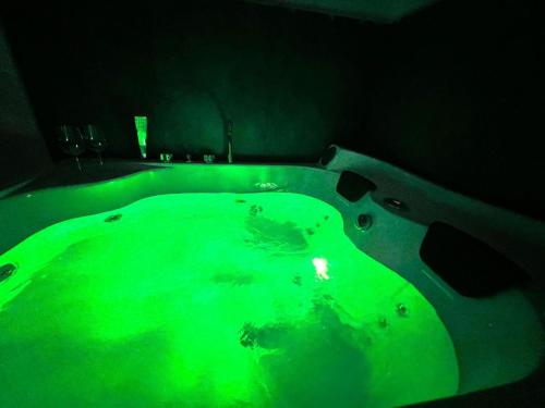 eine grüne Badewanne in einem dunklen Zimmer in der Unterkunft Adua Luxury Apartment in Città Nuova
