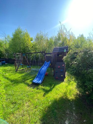 a playground with a slide in the grass at Istebna Pełna Chata I in Istebna