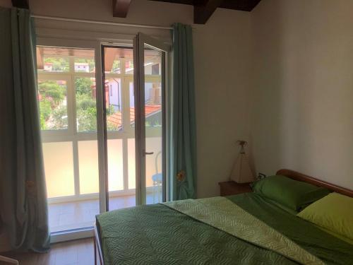 una camera da letto con un letto verde e una finestra di Valentinas retreat a San Dorligo della Valle