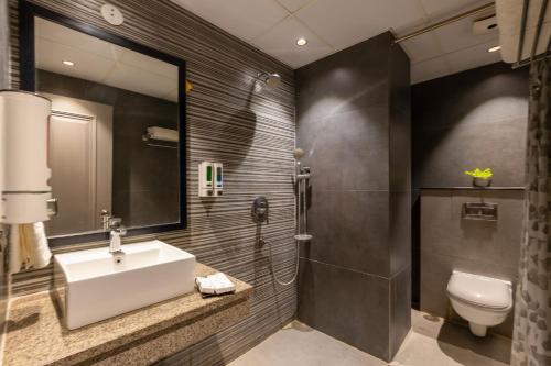 um banheiro com pia e vaso sanitário em Hotel Okas Grand em Nova Deli