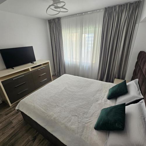 a bedroom with a large bed and a television at Carol Apart in Craiova