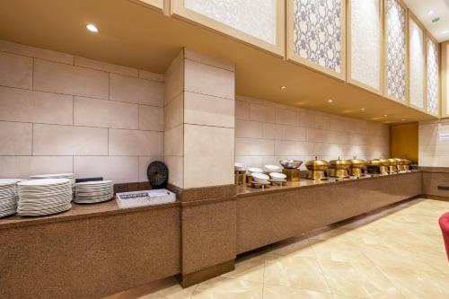 un restaurante con un mostrador con platos en Okas Grand Luxury Collection Hotel Near Crowne Plaza New Delhi Okhla By IHG, en Nueva Delhi