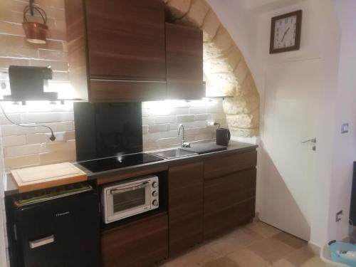 a kitchen with a sink and a microwave at Le Antiche Travi in Bari