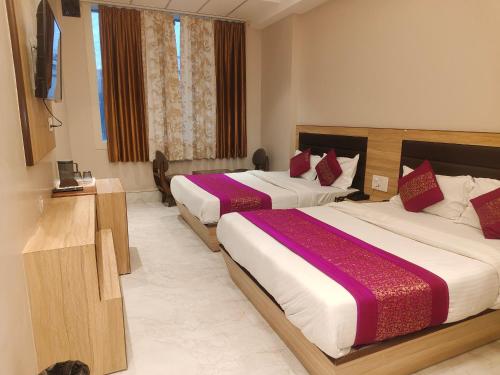 ein Hotelzimmer mit zwei Betten und einem Flachbildfernseher in der Unterkunft Family Rooms Only By Provide The URO Group - Main Bazar Paharganj in Neu-Delhi