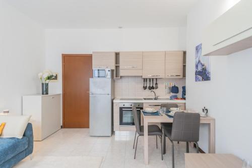 a kitchen and living room with a table and chairs at La Villa Strangiato in Seregno