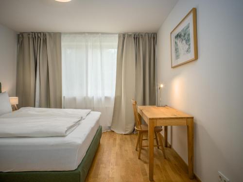 Gardenholm im Süden von Westerland في فيسترلاند: غرفة نوم بها سرير ومكتب وطاولة