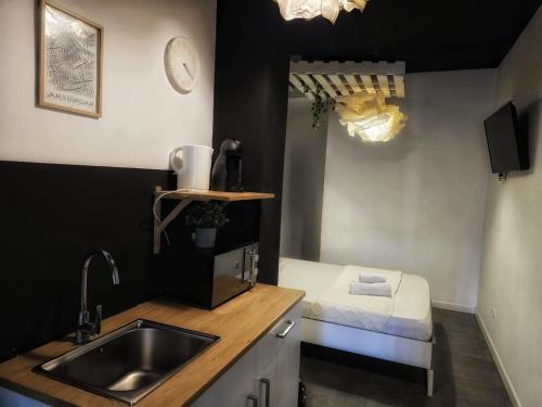 a small kitchen with a sink and a bed at Cozy Room G20 in Valencia