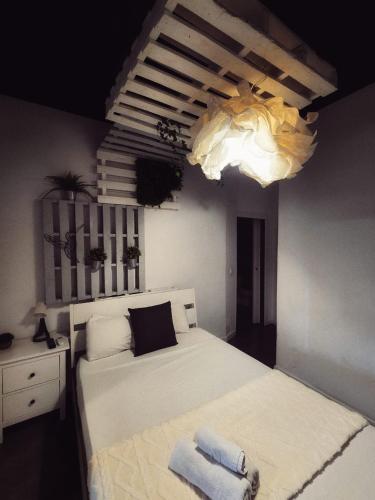 a bedroom with a large white bed and a chandelier at Cozy Room G20 in Valencia