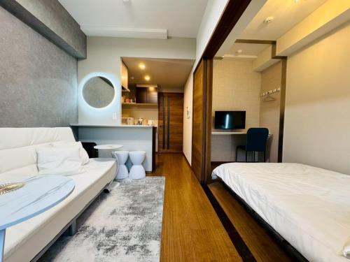 a hotel room with a bed and a couch at LuxurySweet 博多駅南51 in Fukuoka