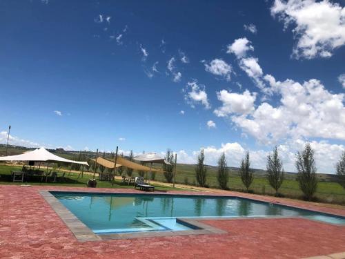 ein Pool mit blauem Himmel im Hintergrund in der Unterkunft Good Times Cafe in Teyateyaneng