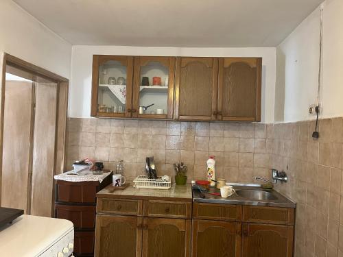a kitchen with wooden cabinets and a sink at Dedina kuća pod Mučnjem in Ivanjica