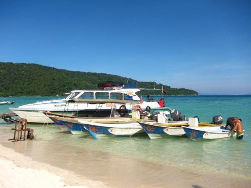 a group of boats parked on the beach at Flora Bay 1 in Perhentian Island