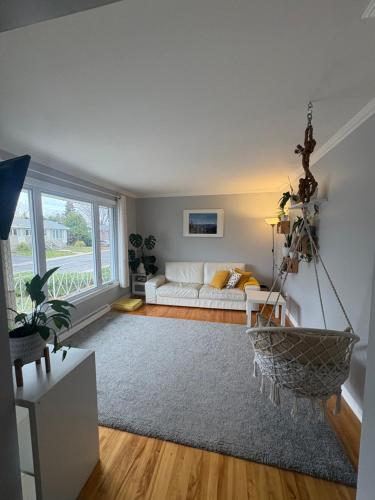 ein Wohnzimmer mit Couch und großem Fenster in der Unterkunft Escapade familiale à Longueuil in Longueuil