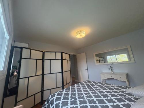 Schlafzimmer mit einem schwarzen und weißen Bett und einem Fenster in der Unterkunft Escapade familiale à Longueuil in Longueuil