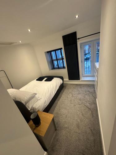 a bedroom with a bed and two windows at Entire house, close to central Bristol in Bristol