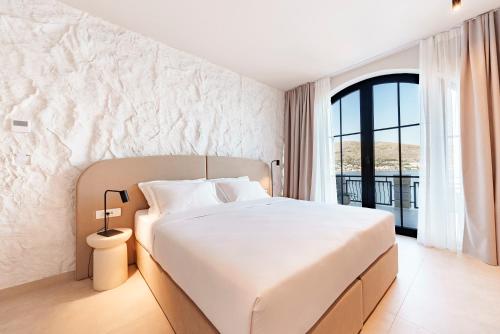 ein Schlafzimmer mit einem weißen Bett und einem großen Fenster in der Unterkunft Vila VitaMaris in Okrug Donji