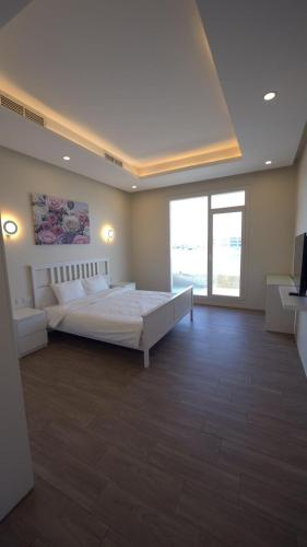 a large bedroom with a bed and a large window at شاليه العائله Shaleeh 285 in Al Khīrān