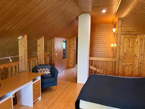 ein Schlafzimmer mit einem Bett und einem Stuhl in einem Zimmer in der Unterkunft Holiday Home Karhu in Istunmäki