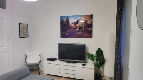 a television sitting on a white cabinet in a living room at Appartement 2 chambres avec garage à strasbourg in Strasbourg