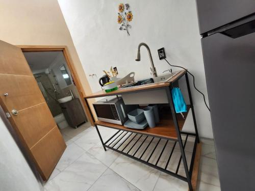 a kitchen with a sink and a microwave at Casa Elbatros in Manzanillo