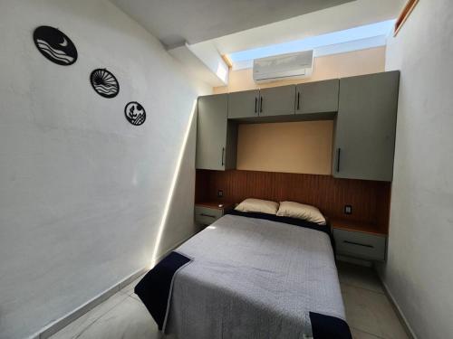 ein kleines Schlafzimmer mit einem Bett in einem Zimmer in der Unterkunft Casa Elbatros in Manzanillo