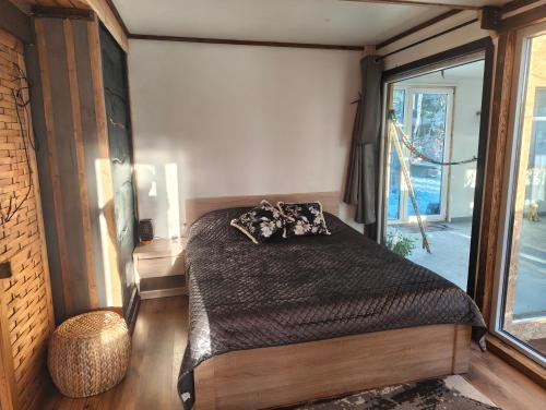 a bedroom with a bed and a large window at Dreamcatcher & Friends in Straupe