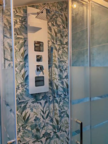 a shower in a bathroom with a wall with plants at Casa La Mora in Giardini Naxos